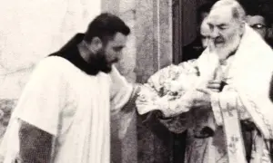 Ojciec Pio, znany ze stygmatów, błogosławi wiernych.
