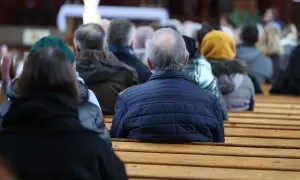 Ludzie siedzą w kościele, wsłuchując się w kazanie o 6 prawdach wiary.
