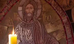 Płaskorzeźba Chrystusa z zapaloną świecą. Wokół napisy, w tym fragmenty nawiązujące do psalmów, np. psalm 99.