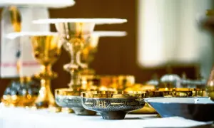 Złote kielichy i naczynia liturgiczne, gotowe na post eucharystyczny.