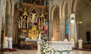 W kościele trwa msza. 1 maja święto kościelne, kapłani w szatach liturgicznych przy ołtarzu.