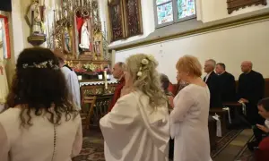 W kościele trwa uroczystość. Kobieta w białej sukni, z kwiatami we włosach, klęczy przed ołtarzem. To moment konsekracji, ważny dla każdej dziewicy konsekrowanej.