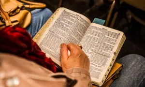 Osoba czyta Biblię, skupiając się na Psalmie 96.