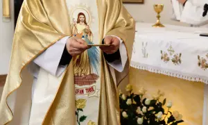 19 czerwca. Kapłan w złotej szacie z wizerunkiem Jezusa trzyma hostię.