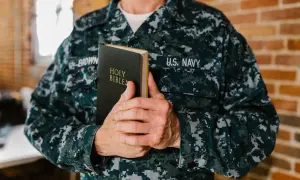 Marynarz US Navy trzyma Biblię. Może to być jego osobista pieśń nad pieśniami interpretacja wiary.