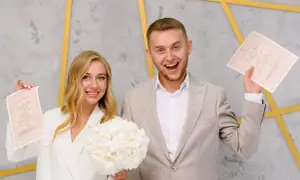 Szczęśliwa para z dokumentami ślubnymi. Czy bierzmowanie jest potrzebne do ślubu? To pytanie nie dotyczy tej radosnej chwili.