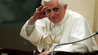 Papież Benedykt XVI, w białej sutannie, pozdrawia, jakby zapowiadając rewolucję seksualną.