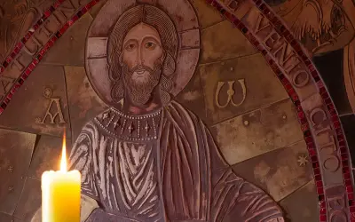 Płaskorzeźba Chrystusa z zapaloną świecą. Wokół napisy, w tym fragmenty nawiązujące do psalmów, np. psalm 99.
