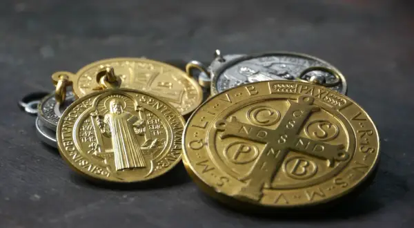 Kilka złotych i srebrnych medalików, w tym cudowny medalik z wizerunkiem świętego.