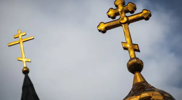Złote krzyże prawosławne na tle nieba. Czy katolik może nosić krzyż prawosławny? Symbol wiary.