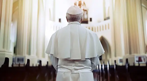 Papież w białej szacie i piusce stoi w kościele, przygotowując się do uroczystej beatyfikacji.