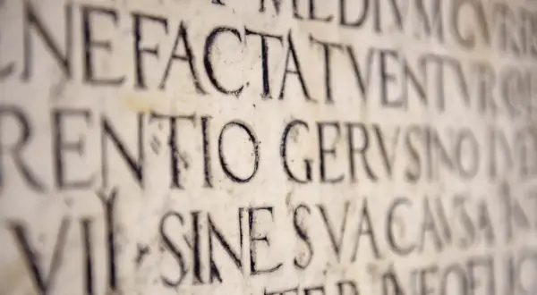 Kamienne inskrypcje z łacińskimi słowami, w tym "dei", wyryte w starożytnym stylu.