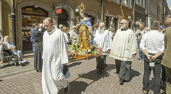 Procesja z figurą Matki Boskiej. Czy w Boże Ciało trzeba iść do kościoła? Wierni niosą figurę ulicą, niektórzy w strojach duchownych.
