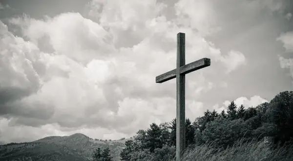 Drewniany krzyż na tle burzowych chmur i górskich krajobrazów. Jak w psalm 31, symbol nadziei i wiary.