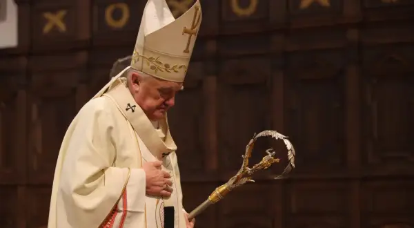 Biskup Nycz w białej szacie i mitrze z krzyżem, trzyma pastorał.