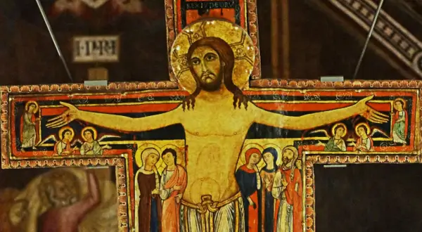 Stary krzyż franciszkański z malowanymi postaciami Jezusa, aniołów i świętych.