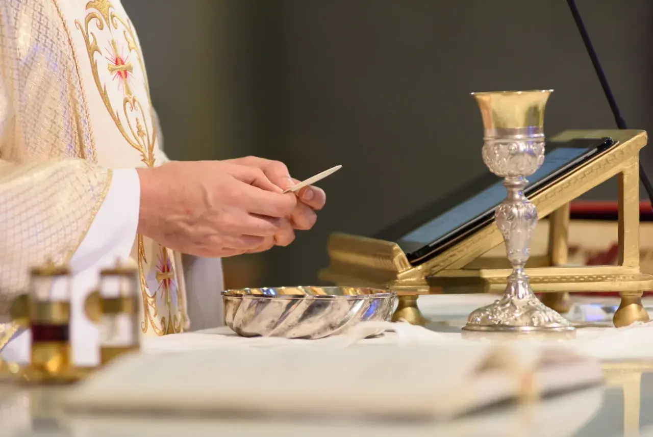 Kapłan trzyma opłatek, przygotowując się do Eucharystii. Co to jest Eucharystia? To sakrament.