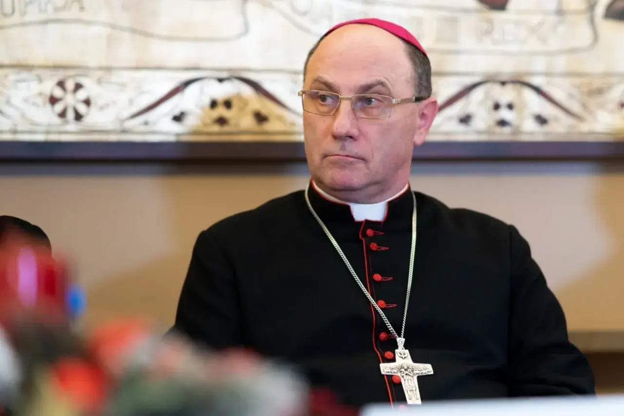 Prymas Polski w okularach i czarnej sutannie z krzyżem na łańcuszku.