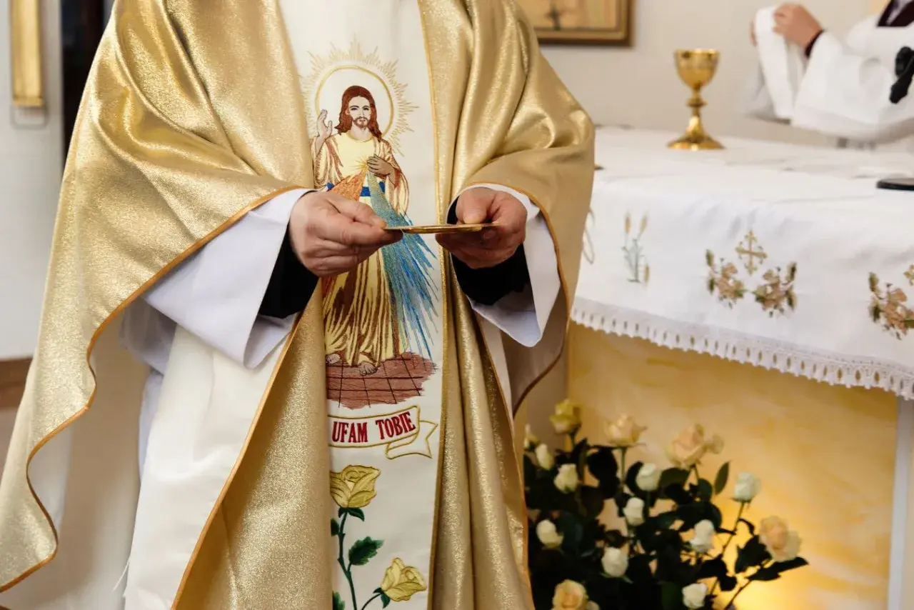 19 czerwca. Kapłan w złotej szacie z wizerunkiem Jezusa trzyma hostię.