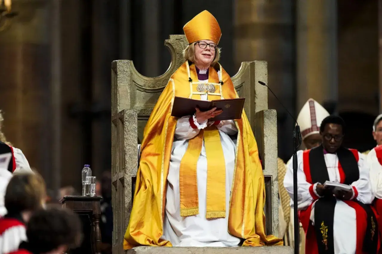 Arcybiskup Canterbury w złotej szacie i mitrze, siedzi na tronie, trzymając księgę.