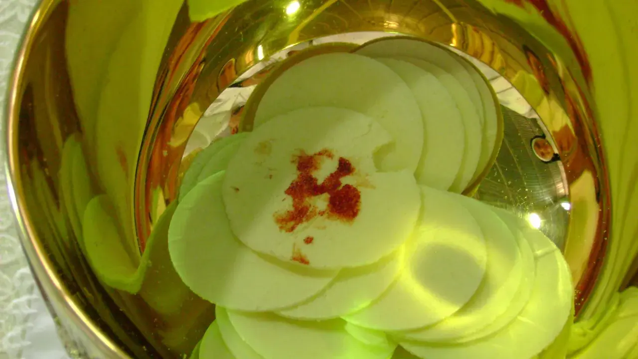 Hostia z plamą przypominającą krew, symbolizująca cud eucharystyczny w Sokółce, w złotym naczyniu.