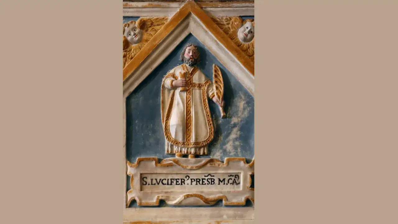 Rzeźba przedstawia św. Lucifera, prezbitera, w białej szacie z ozdobnym pasem. Trzyma palmę męczeństwa i kielich.