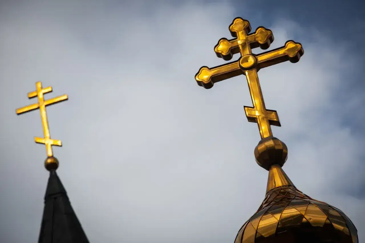 Złote krzyże prawosławne na tle nieba. Czy katolik może nosić krzyż prawosławny? Symbolika wiary.