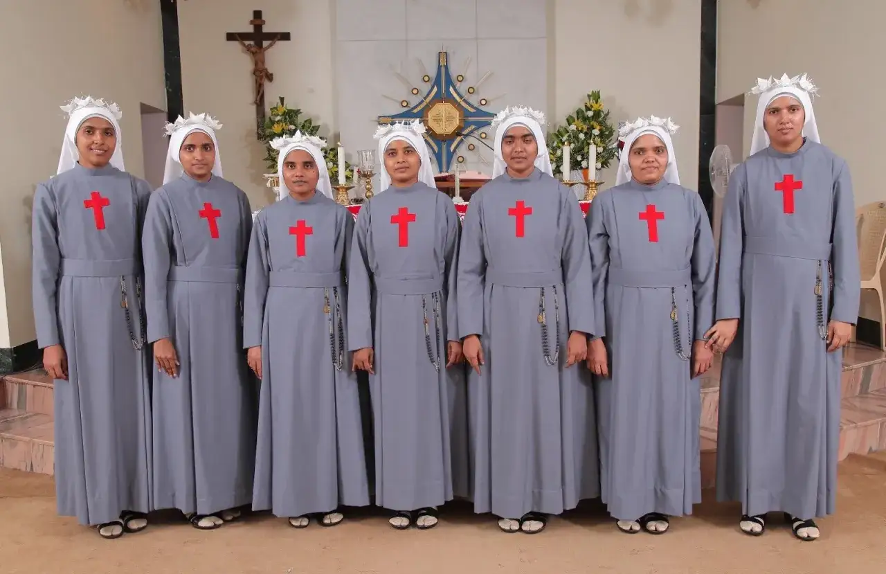 Siedem zakonnic w szarych habitach z czerwonymi krzyżami, w białych nakryciach głowy. Ich habit to symbol ich ślubów i codziennego habit.