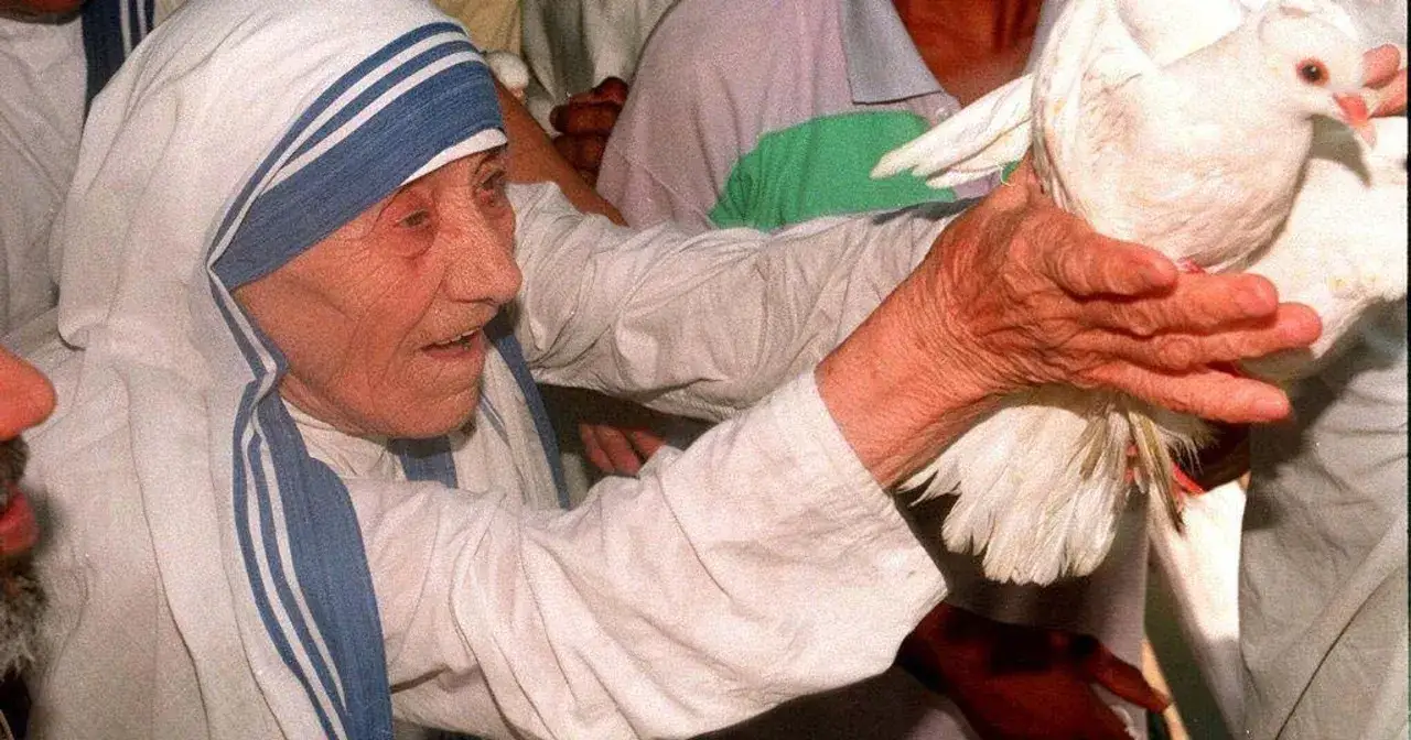 Matka Teresa z Kalkuty, otoczona ludźmi, trzyma gołębia. Wokół niej rozchodzą się plotki i zarzuty, ale ona wciąż emanuje spokojem.