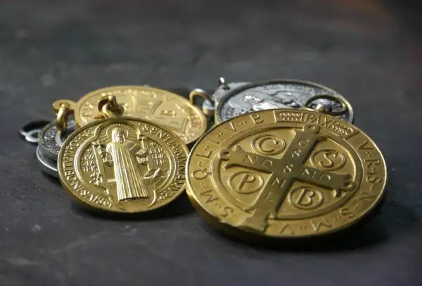 Kilka złotych i srebrnych medalików, w tym cudowny medalik z wizerunkiem świętego.