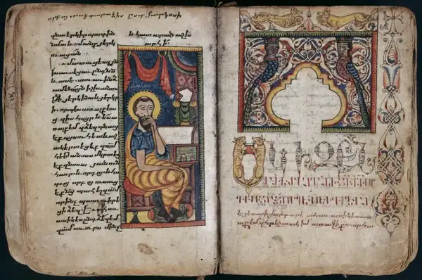 Ilustracja z Ewangelii św. Marka: święty siedzi przy biurku, pisząc. Obok ozdobne inicjały i miniatury.