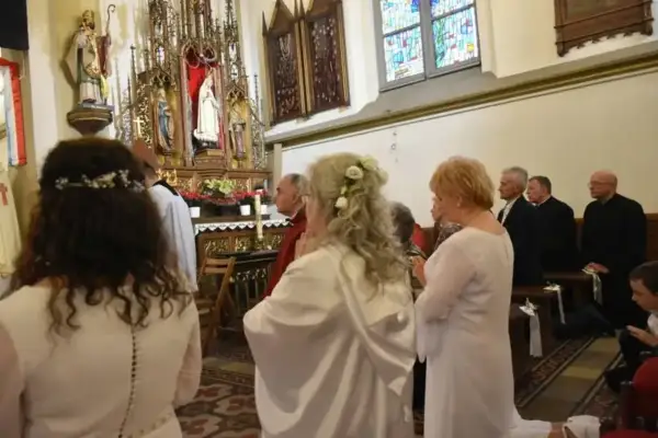 W kościele trwa uroczystość. Kobieta w białej sukni, z kwiatami we włosach, klęczy przed ołtarzem. To moment konsekracji, ważny dla każdej dziewicy konsekrowanej.